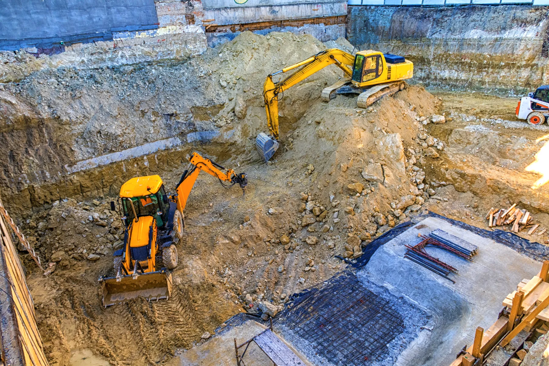Heavy construction equipment actively working on an outdoor excavation project.